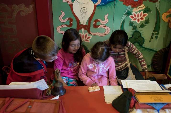 The children play with an iPad during a ceremony. Image courtesy of Henrique Gasper