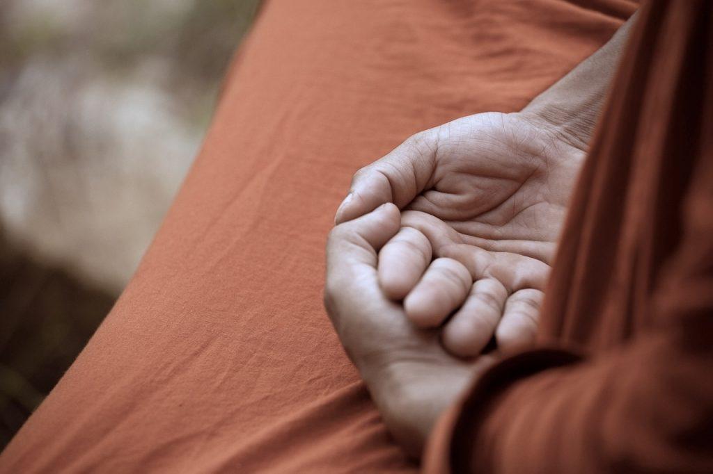 Folded hands of a meditating Buddhist monk