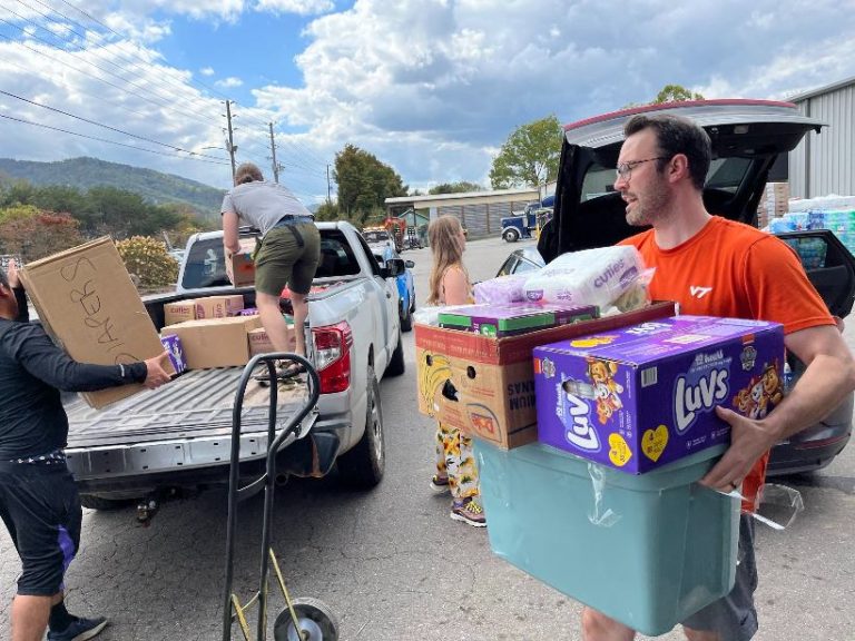 people load boxes of supplies onto a truck for distribution