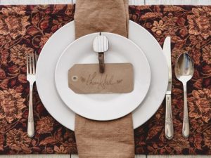 A formal dinner setting with the word thankful written across it