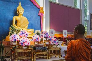 Buddhist monk before a Buddha statue