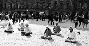 a black and white image of people in meditation posture