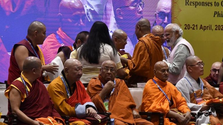 Narendra Modi in a room with many monks