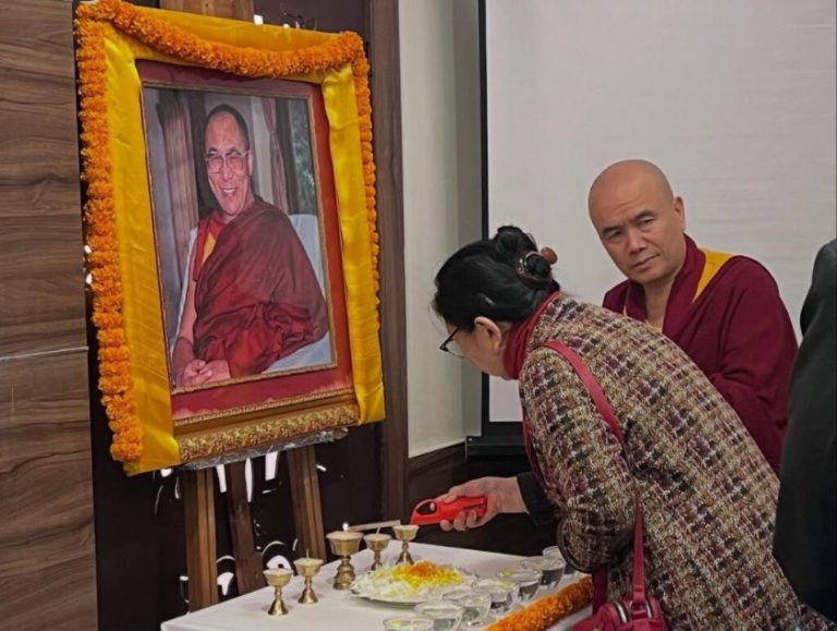 Education Minister (Kalon) Tharlam Dolma Changra of the Central Tibetan Administration lights a candle before a portrait of the Dalai Lama