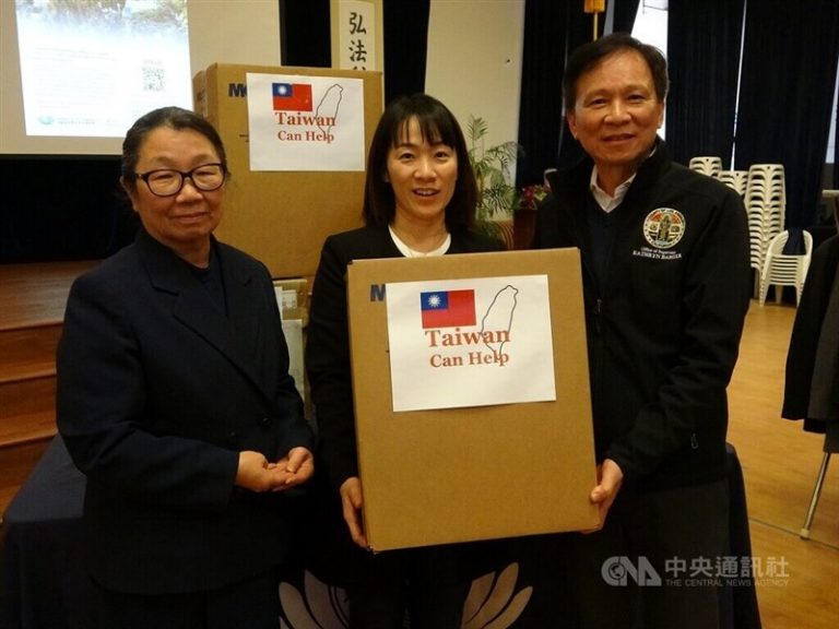 Volunteers hold boxes with "Taiwan can help" written on them.