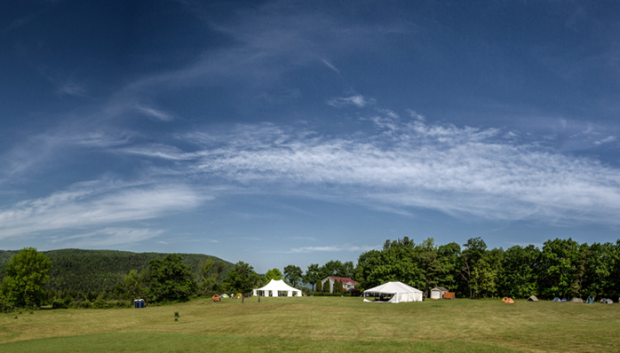 buildings on grassy field with blue sky above